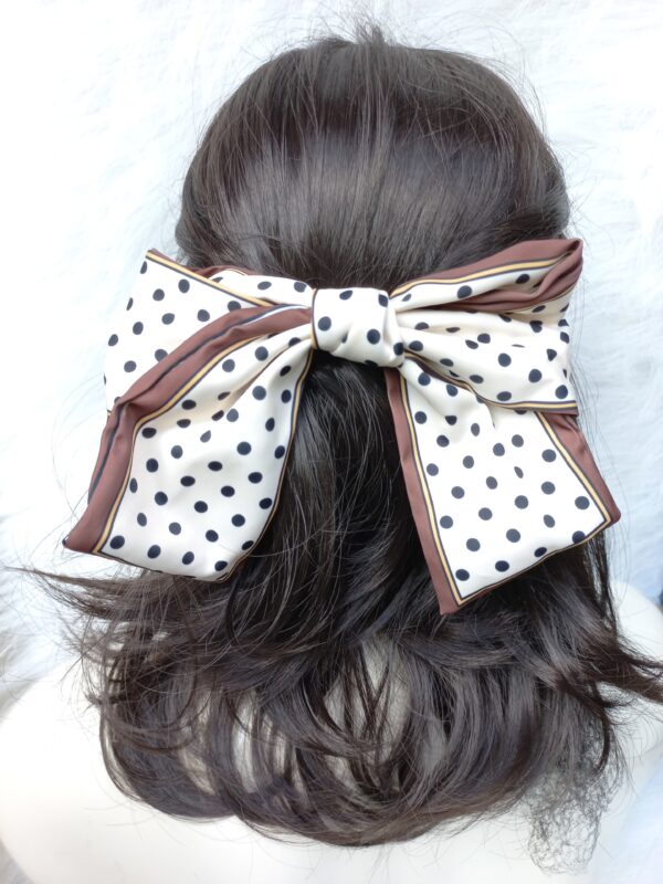 shows the bow worn in hair for comparative size
